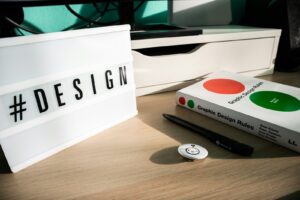 a desk with a book, pen and remote control